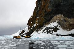 06A Zodiacs In Loose Ice In Paradise Harbour Below Lichen Covered Rock And Blue-Eyed Shag Nests On Quark Expeditions Antarctica Cruise.jpg